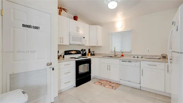 a kitchen with white cabinets sink and white appliances