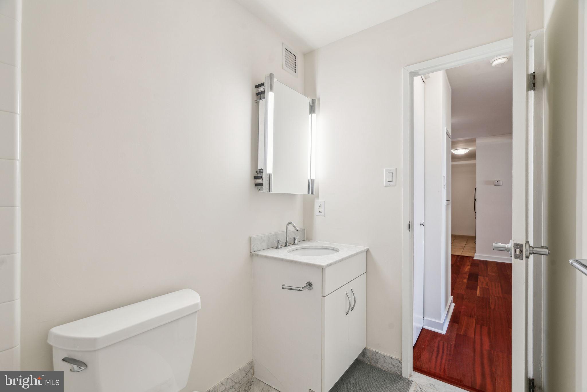 219-29 South 18th Street, Unit 1515 Philadelphia, PA 19103 - Photo 6 of 9 a bathroom with a toilet sink and mirror