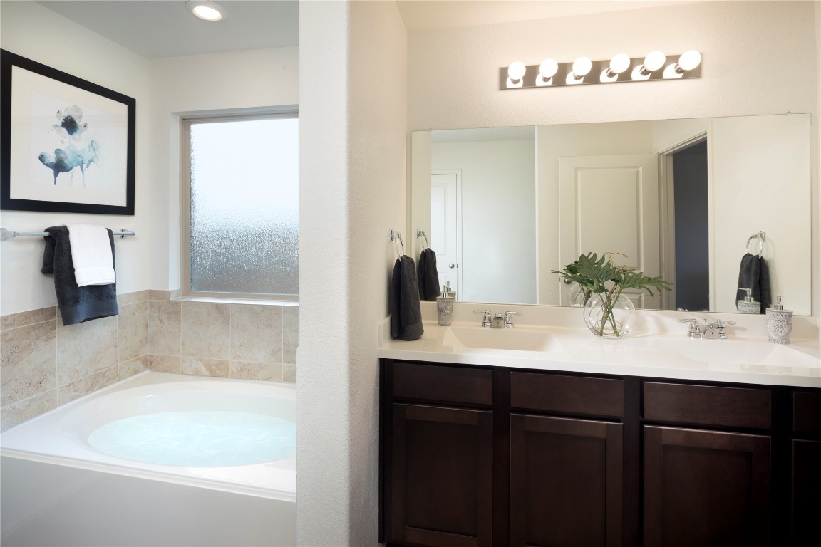 1133 Nesting Bird Drive Georgetown, TX 78628 - Photo 8 of 10 a bathroom with a bathtub sink and mirror