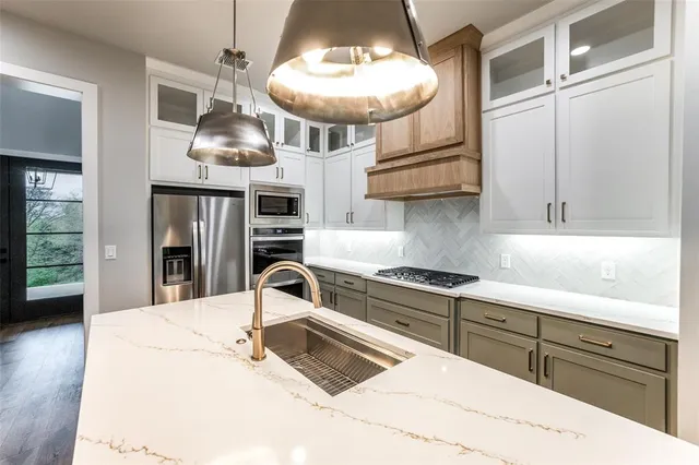 a kitchen with stainless steel appliances a sink a stove and cabinets