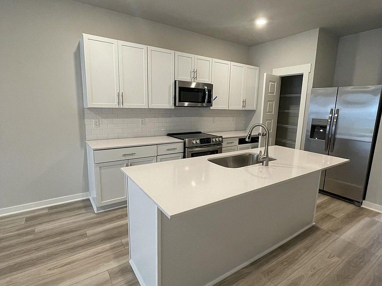 702 Mickelson Way, Unit 702 Lebanon, TN 37087 - Photo 4 of 17 a kitchen with stainless steel appliances a sink a stove a microwave and cabinets
