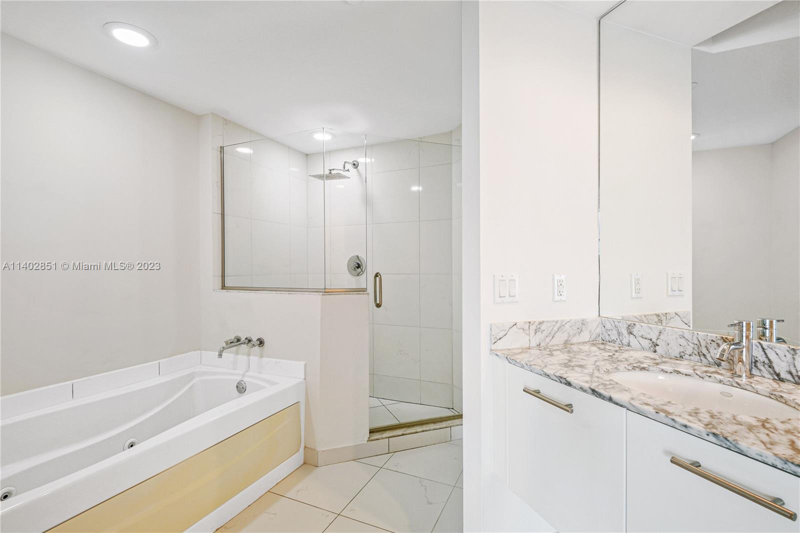 500 Brickell Avenue, Unit 2007 Miami, FL 33131 - Photo 11 of 31 a bathroom with a granite countertop sink a mirror and a bathtub