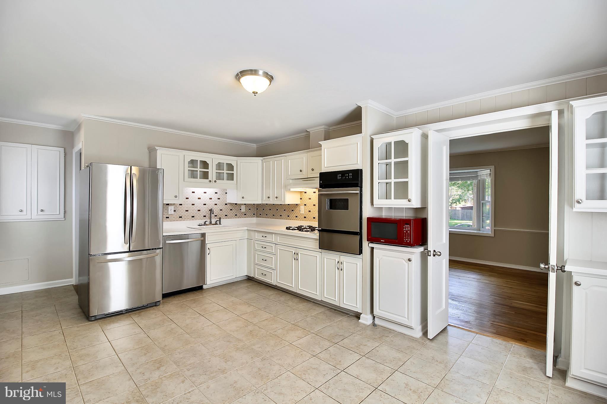 13106 Estelle Road Silver Spring, MD 20906 - Photo 6 of 21 a kitchen with white cabinets and stainless steel appliances