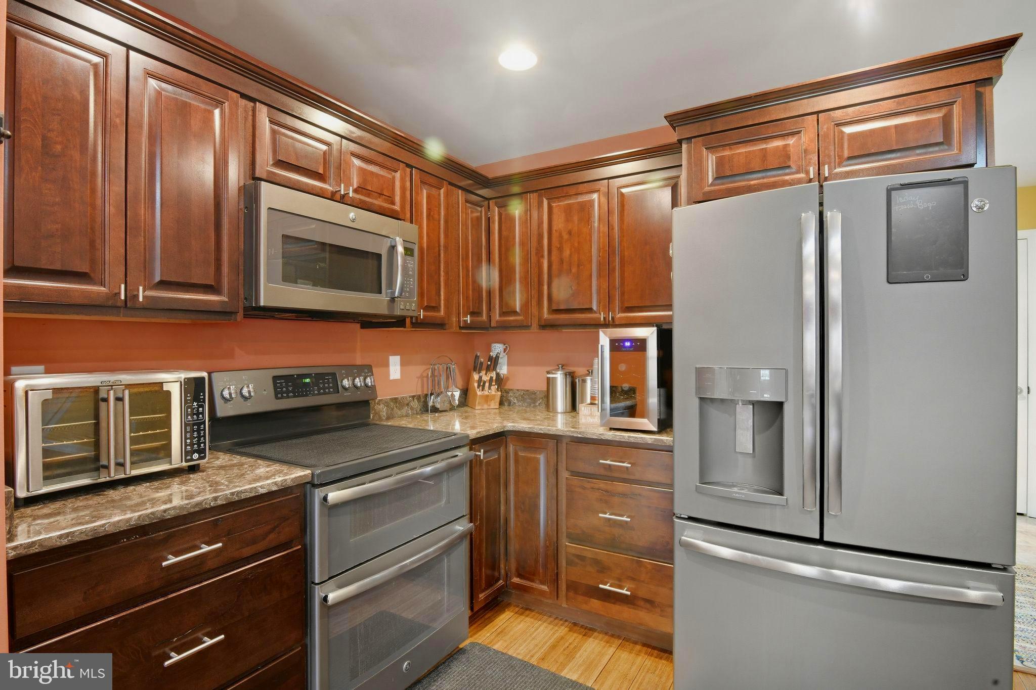 24712 Tribbett Circle Ridgely, MD 21660 - Photo 20 of 37 a kitchen with stainless steel appliances granite countertop a refrigerator and a stove top oven