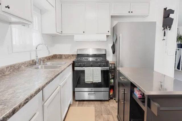 a kitchen with stainless steel appliances granite countertop a sink and a stove