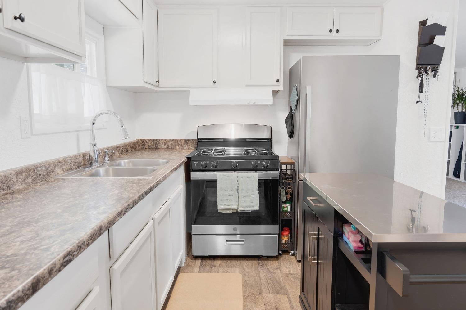 10035 Mills Station Road, Unit 153 Sacramento, CA 95827 - Photo 11 of 23 a kitchen with stainless steel appliances granite countertop a sink and a stove
