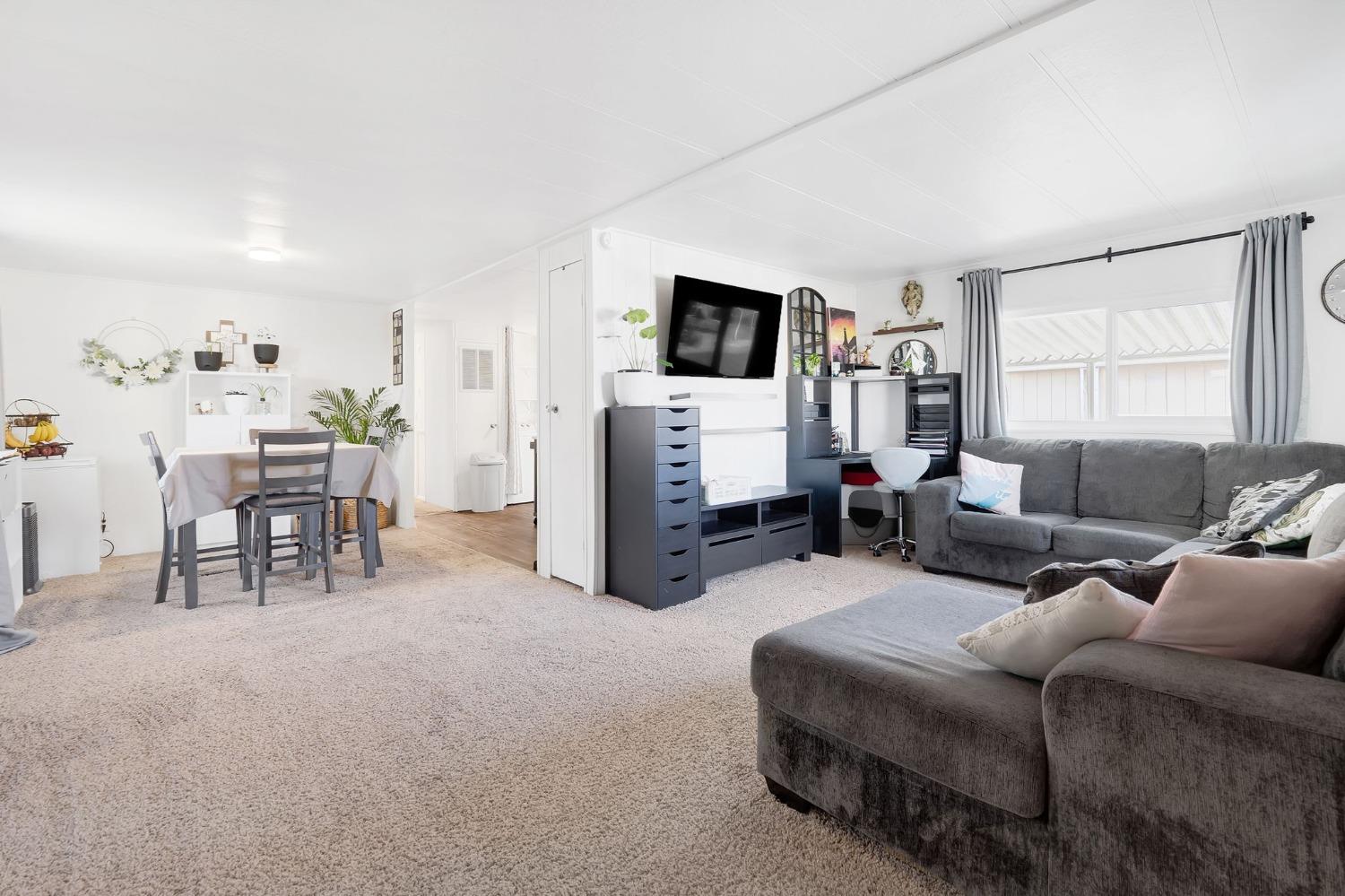 10035 Mills Station Road, Unit 153 Sacramento, CA 95827 - Photo 4 of 23 a living room with furniture and a flat screen tv