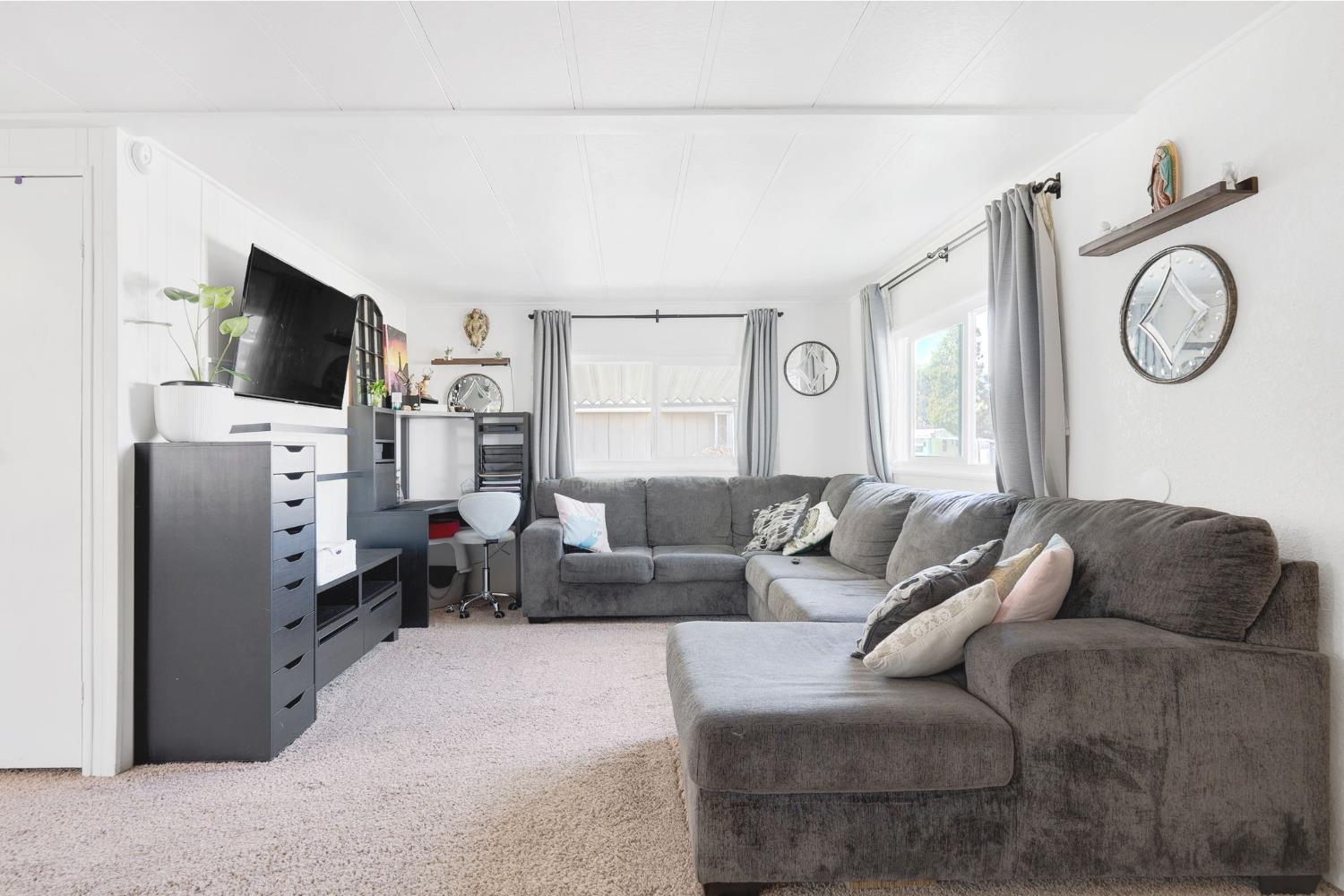 10035 Mills Station Road, Unit 153 Sacramento, CA 95827 - Photo 5 of 23 a living room with furniture a flat screen tv and a large window