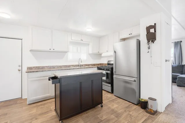 a kitchen with a refrigerator sink and cabinets