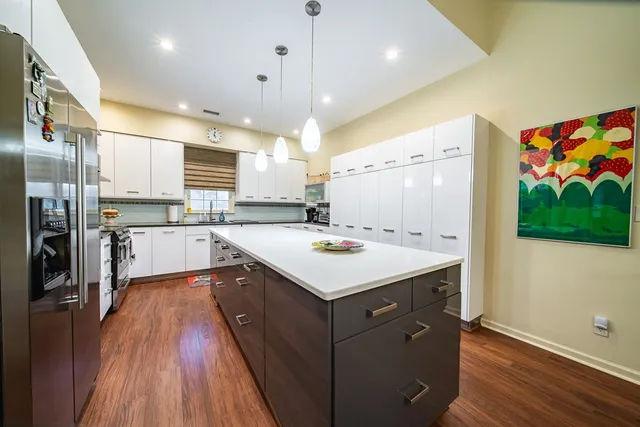 a kitchen that has a lot of cabinets and wooden floor