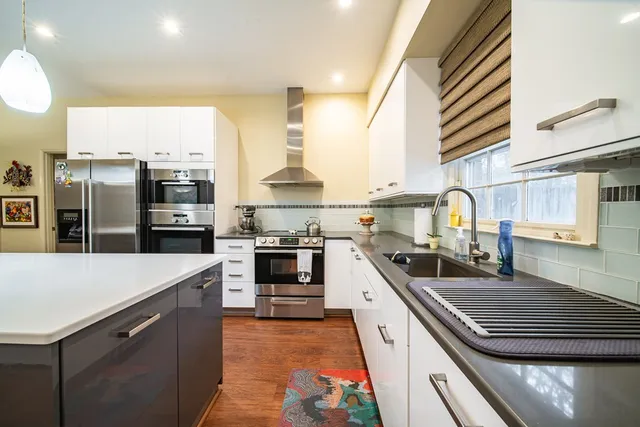 a kitchen with stainless steel appliances a sink dishwasher stove and refrigerator