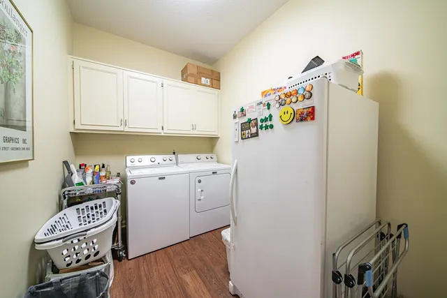 a utility room with fridge dryer and washer