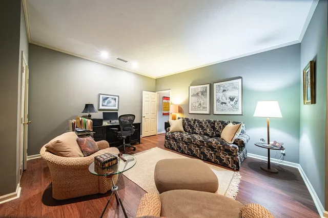 a living room with furniture and a wooden floor