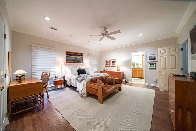 a spacious bedroom with a bed and wooden floor