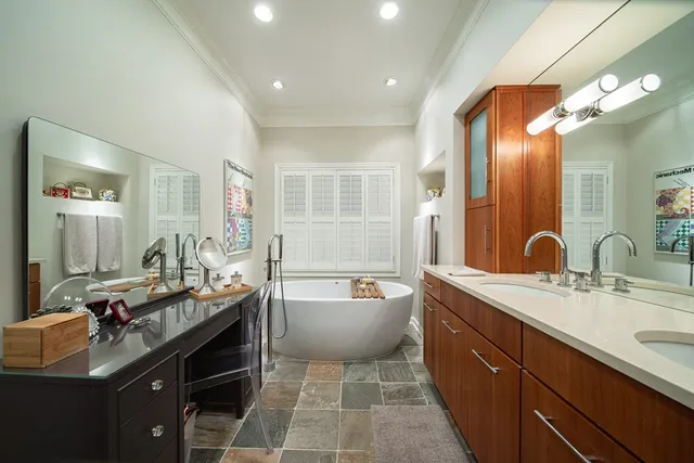 a spacious bathroom with a double vanity sink a mirror and a bathtub