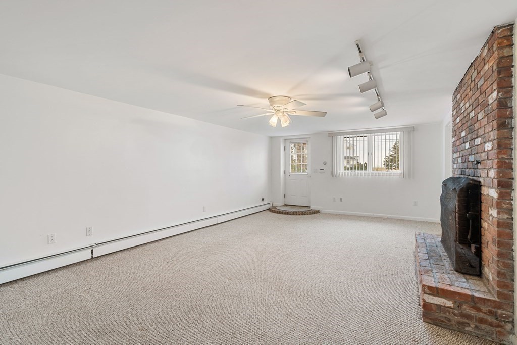 21 Fishermans Cove Road Wareham, MA 02532 - Photo 18 of 34 an empty room with windows and fireplace