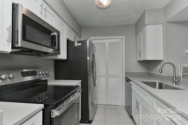 a kitchen with stainless steel appliances granite countertop a sink stove and microwave