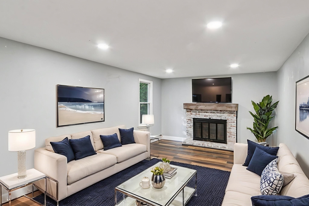 207 Boxboro Road Stow, MA 01775 - Photo 3 of 20 a living room with furniture a fireplace and a flat screen tv