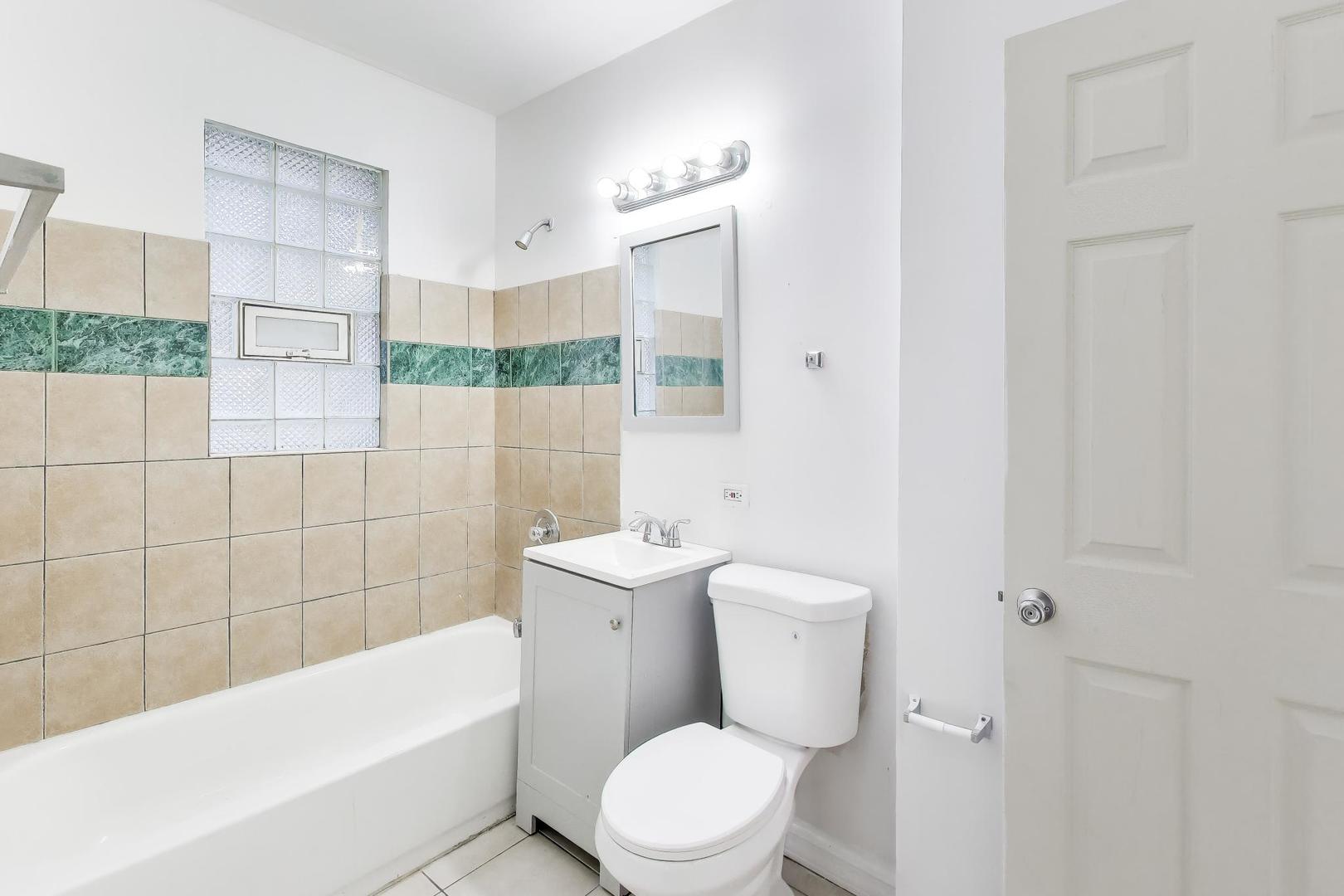 6853 South Perry Avenue Chicago, IL 60621 - Photo 11 of 28 a white toilet sitting next to a bathroom sink and tub