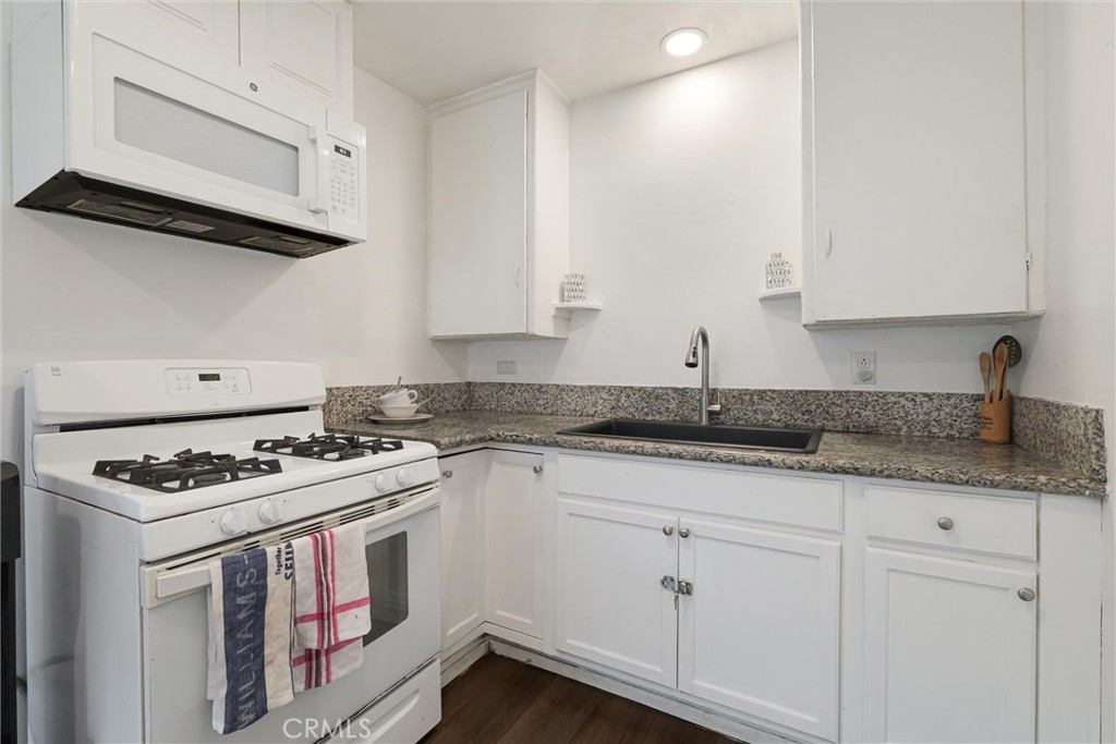 21719 Neptune Avenue Carson, CA 90745 - Photo 6 of 15 a kitchen with granite countertop stainless steel appliances a sink a stove and cabinets
