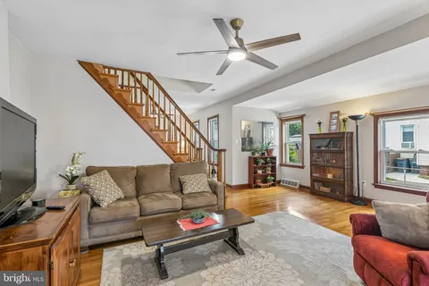 a living room with furniture and a flat screen tv with kitchen view