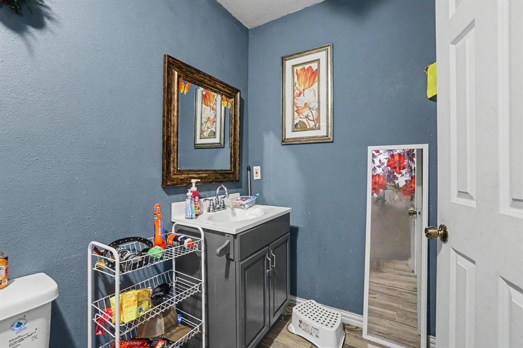 205 South Main Street Bonham, TX 75418 - Photo 17 of 23 a bathroom with a sink mirror and toilet