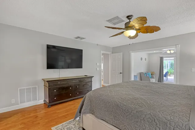 a backyard of a house with table and chairs under an umbrella