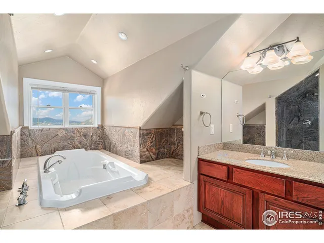 a bathroom with a sink a large mirror and a bathtub