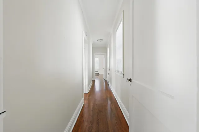 a view of a hallway with wooden floor