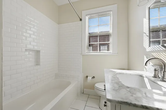 a bathroom with a granite countertop sink toilet and bathtub