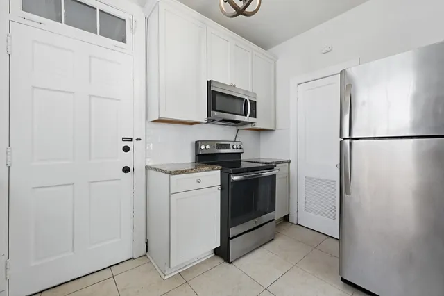 a kitchen with stainless steel appliances granite countertop white refrigerator stove a microwave and oven