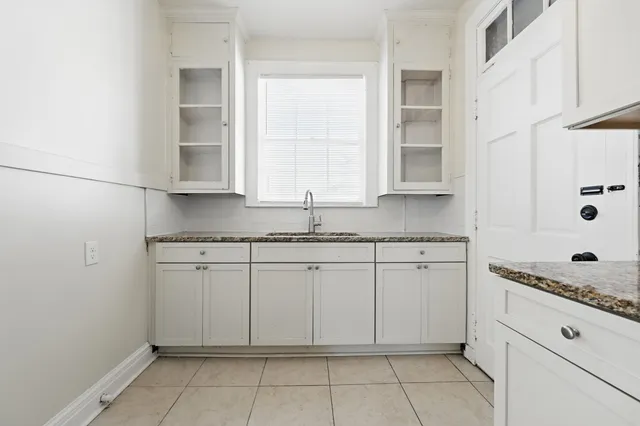 a kitchen with granite countertop white cabinets and white appliances