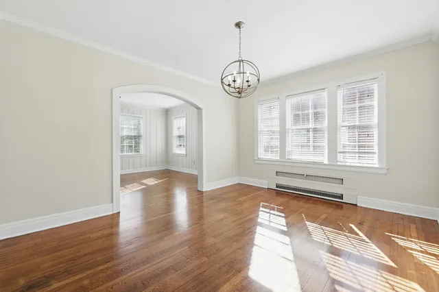 a view of empty room with wooden floor and window