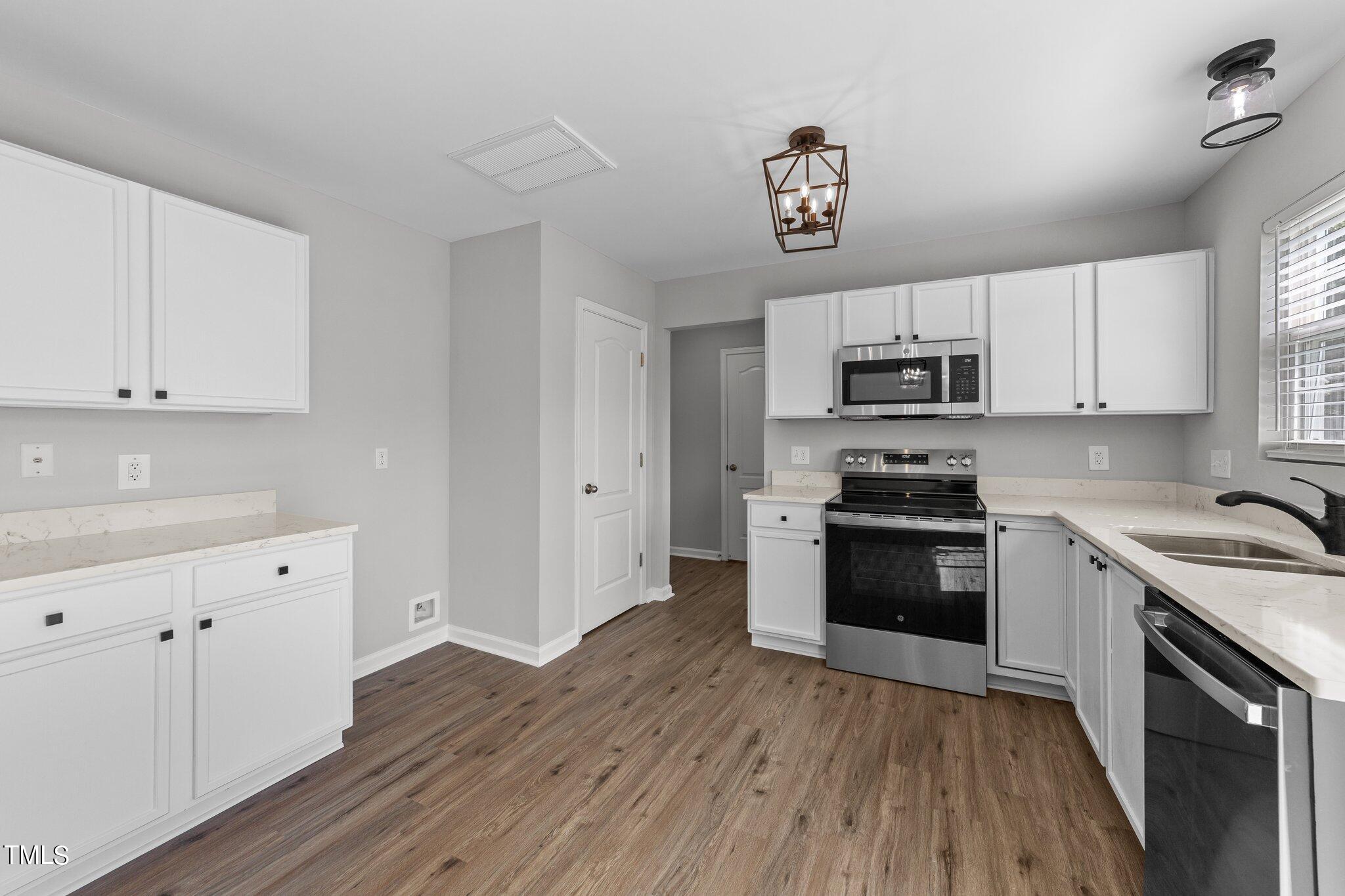 2909 Hayling Drive Raleigh, NC 27610 - Photo 13 of 35 a kitchen with granite countertop a sink cabinets and stainless steel appliances