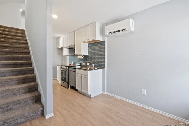 a kitchen with a refrigerator and white cabinets