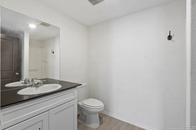 a bathroom with a sink a toilet and mirror