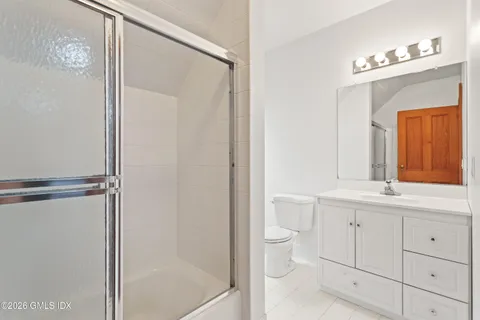 a bathroom with a double vanity sink toilet mirror and bathtub