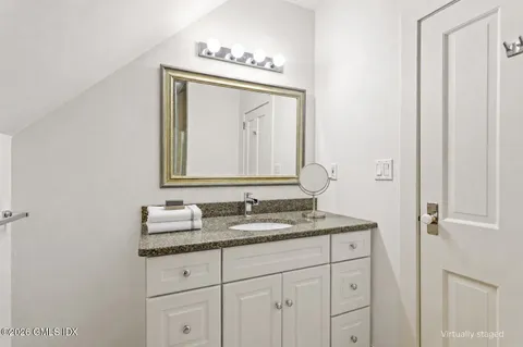 a bathroom with a granite countertop sink vanity and mirror