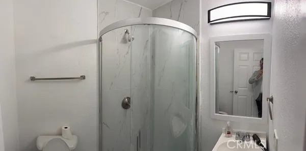 a bathroom with a granite countertop shower a toilet and a sink