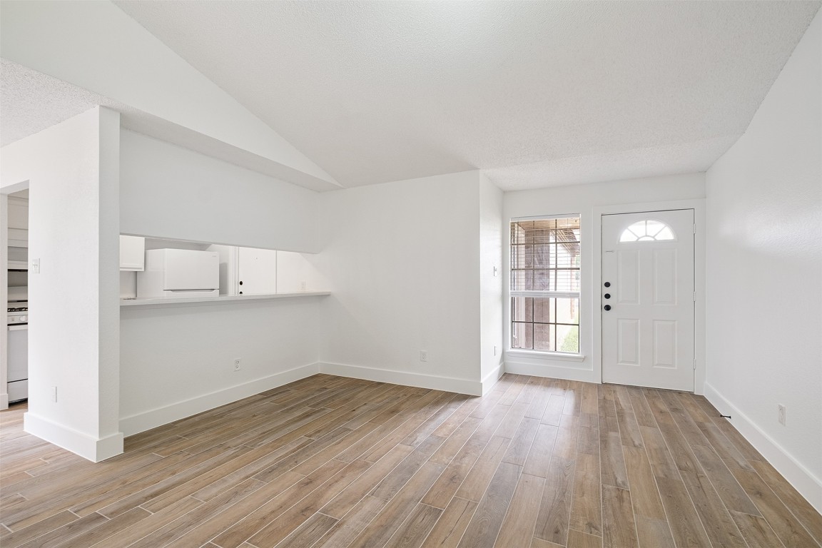 a view of empty room with wooden floor