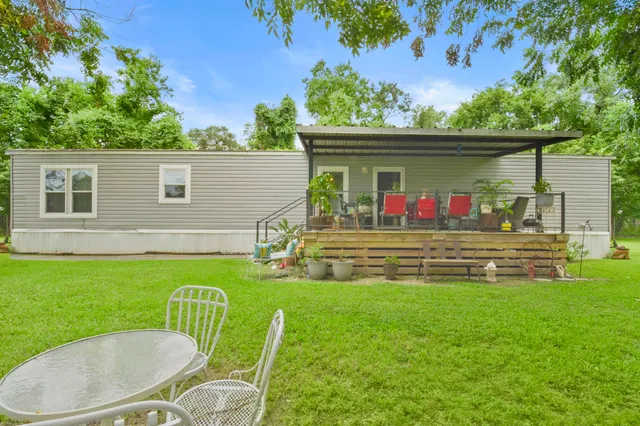 a view of a chair and table in the back yard of the house
