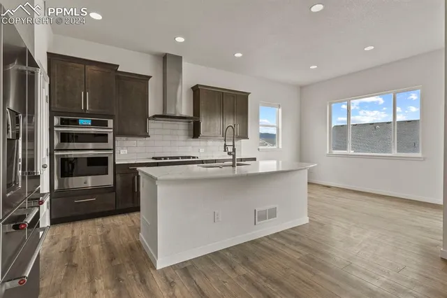a kitchen with stainless steel appliances granite countertop a stove a sink and a refrigerator