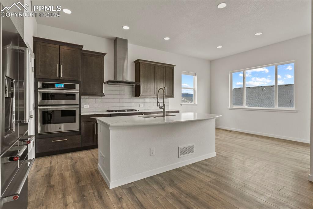 1094 Rambling Oak Drive Monument, CO 80132 - Photo 12 of 44 a kitchen with stainless steel appliances granite countertop a stove a sink and a refrigerator