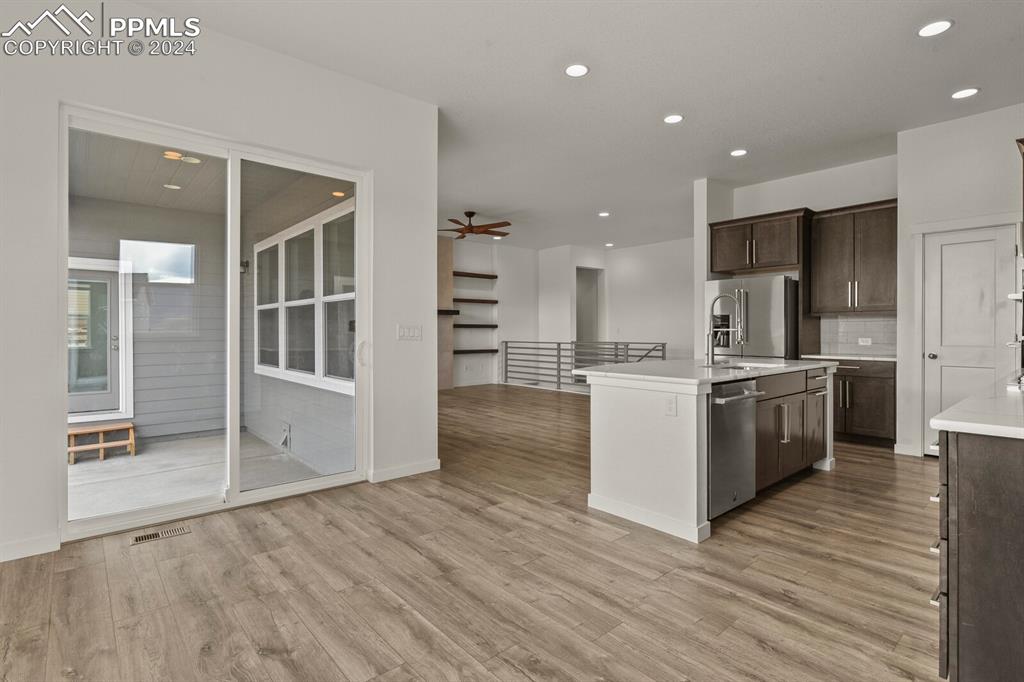1094 Rambling Oak Drive Monument, CO 80132 - Photo 14 of 44 a kitchen with stainless steel appliances wooden floor and white cabinets