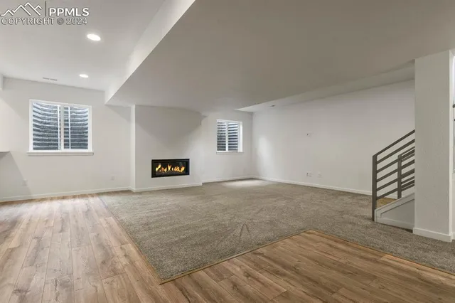 an empty room with windows and cabinet