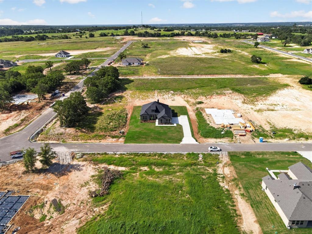 416 McAlpine Drive Springtown, TX 76082 - Photo 37 of 40 Newly constructed residence with a dark-toned exterior and a matching dark roof, set on a graded lot with a recently installed lawn