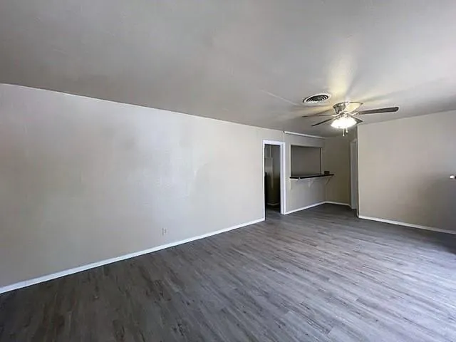 a view of wooden floor and a chandelier fan in a room