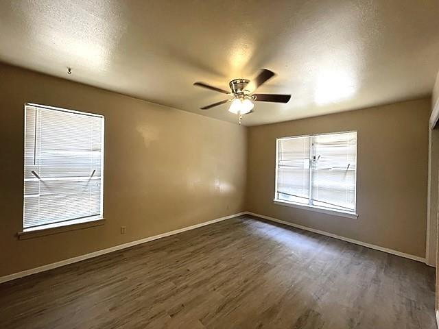 10 Pershing Drive, Unit A Denison, TX 75020 - Photo 9 of 13 an empty room with wooden floor and windows