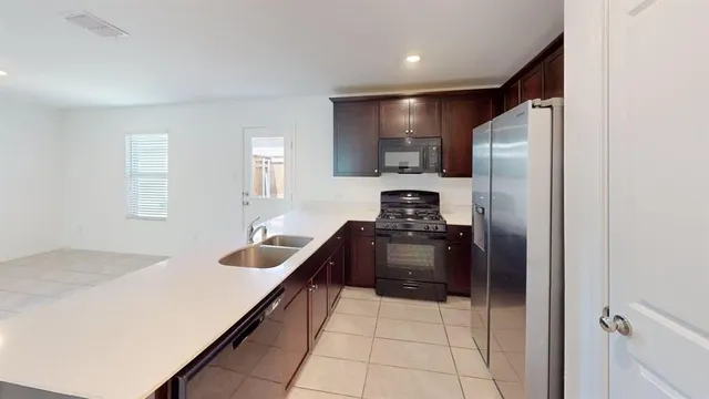 a kitchen with granite countertop a refrigerator and a sink