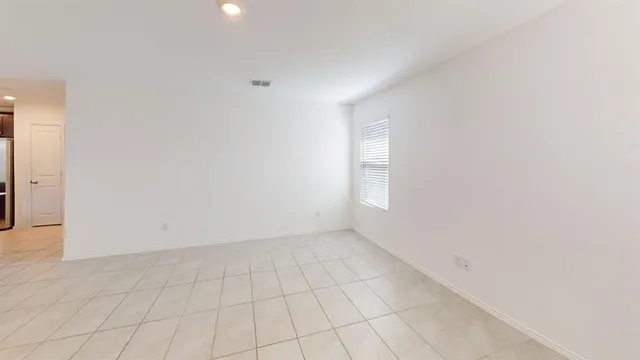 an empty room with white walls and tiles